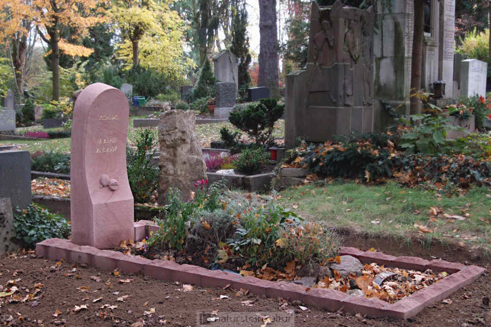Der Grabstein aus rotem Sandstein steht auf dem Mainzer Hauptfriedhof.