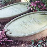 Zwei liegende Urnengrabsteine als Medaillons