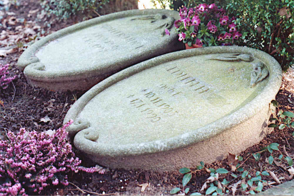 Zwei liegende Urnengrabsteine als Medaillons